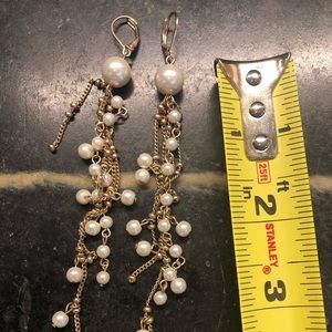 Golden and pearl like long dangle earrings.
